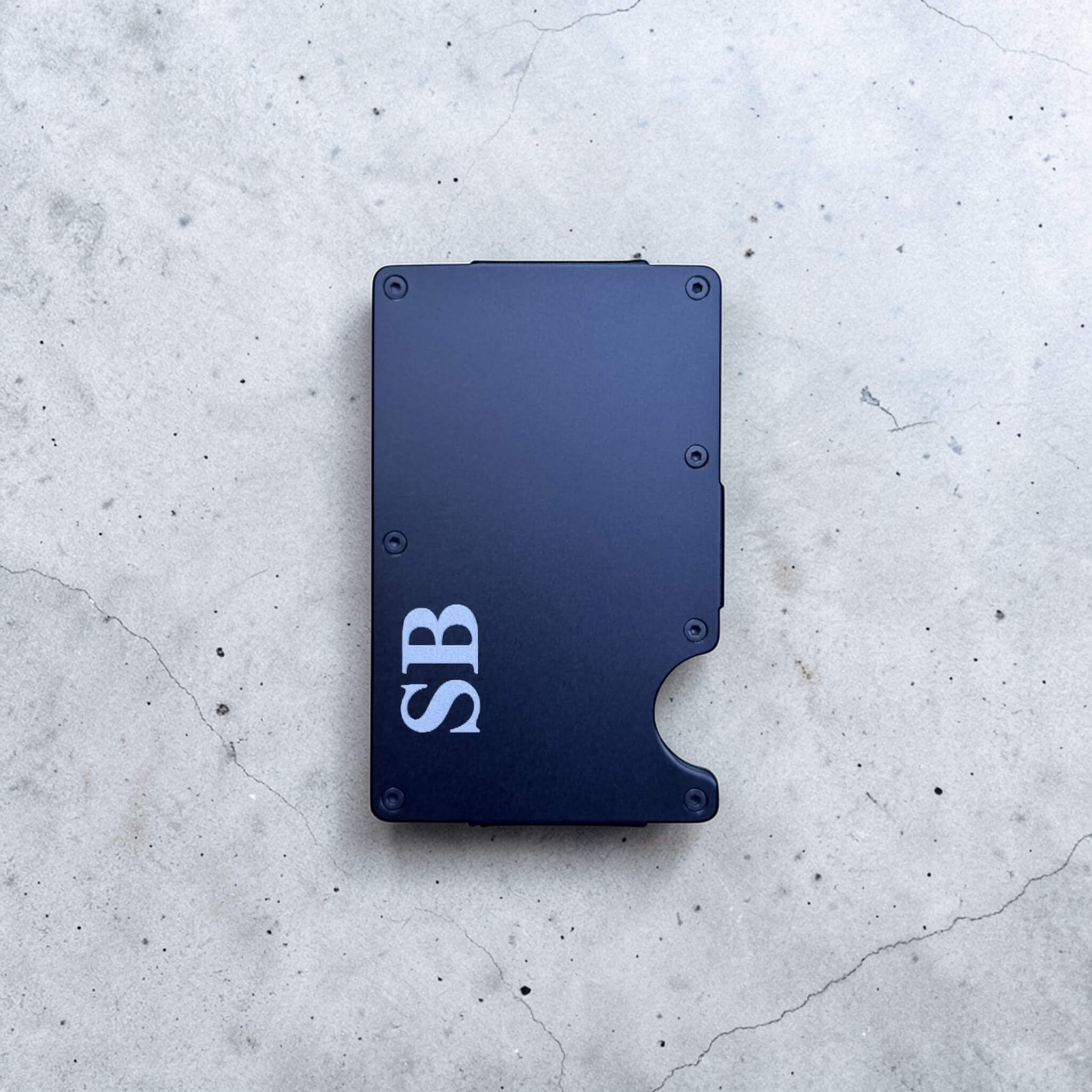 Custom engraved navy blue metal card holder with laser engraved initials, personalised slim RFID blocking wallet on concrete