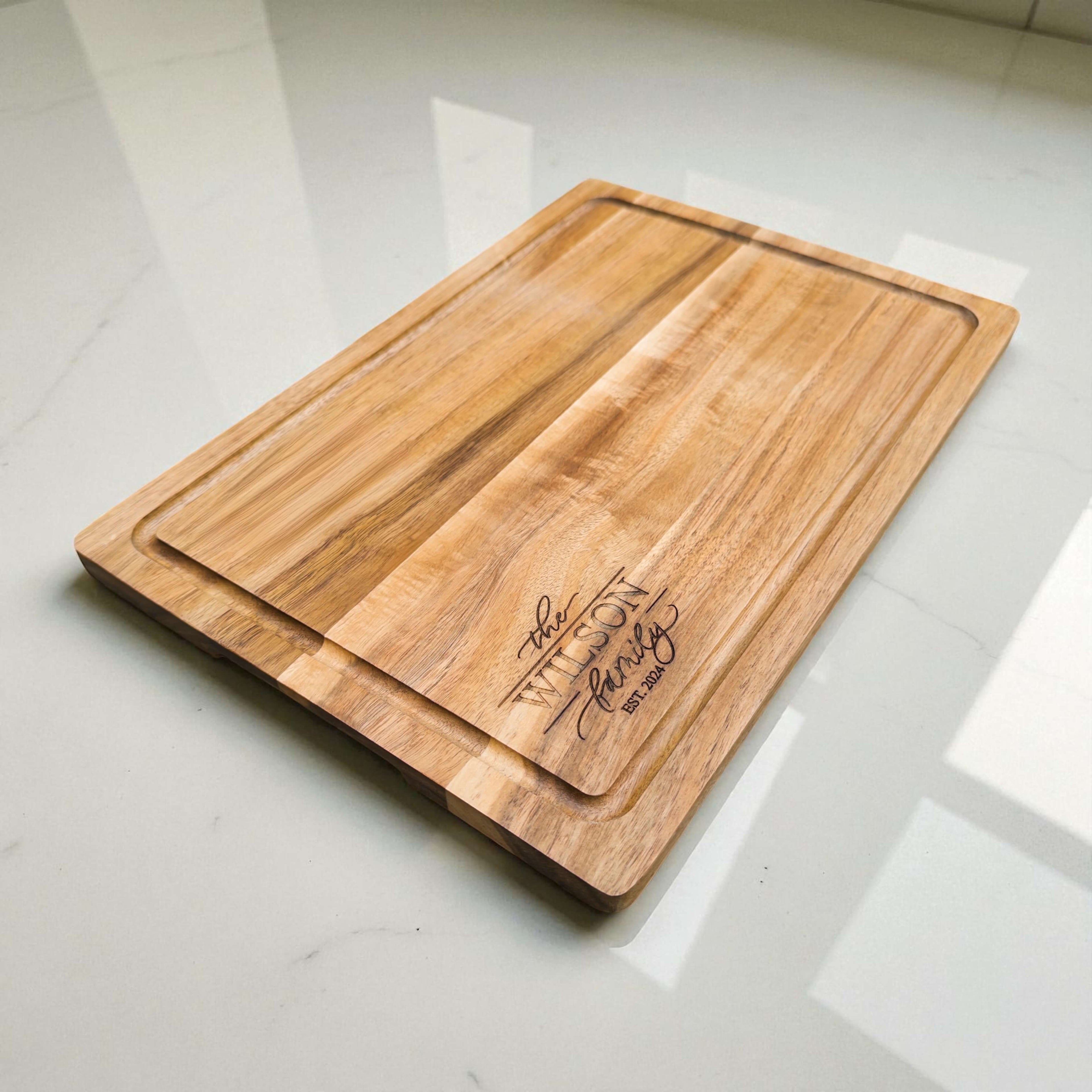 Custom engraved wooden cutting board with family name and established year, sustainable acacia board for kitchen or home décor gift.