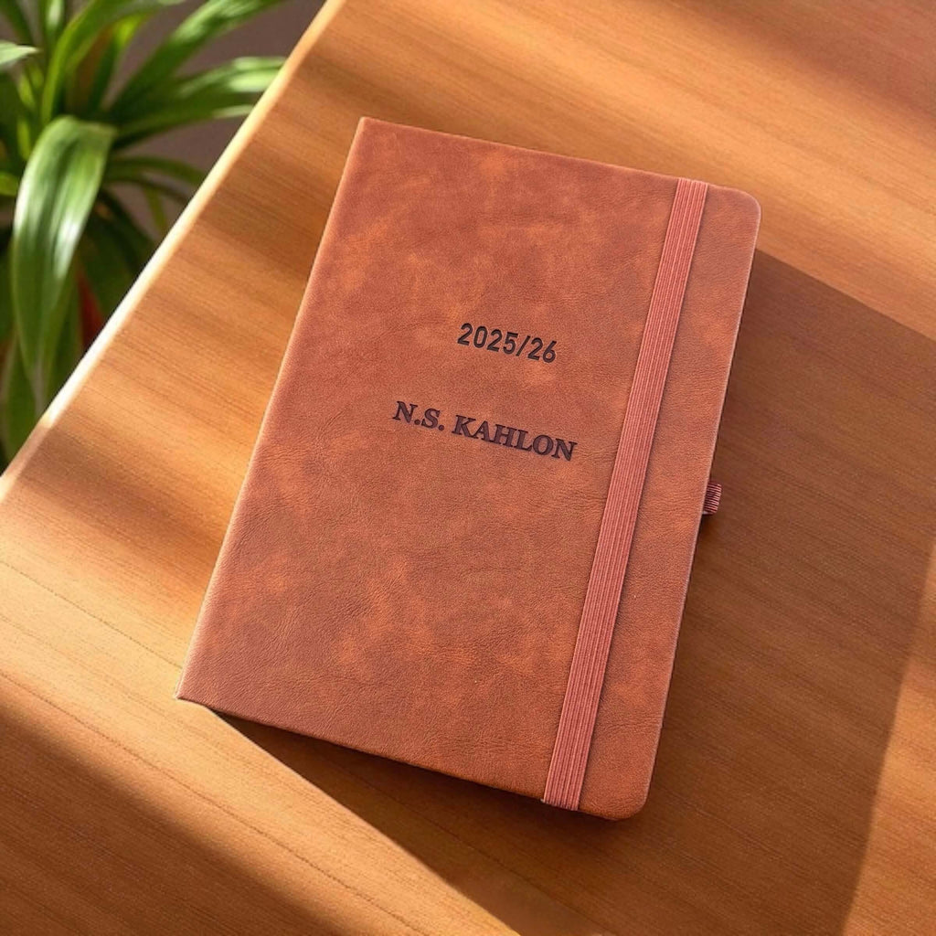 Custom leather planner with engraved message area and soft indoor plant background