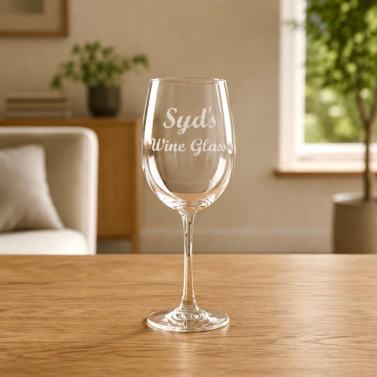 Custom name engraved wine glass personalised with Syd's Wine Glass in elegant script, photographed on a timber table with natural light