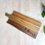 Detail shot of laser-engraved company logo on rich acacia wood paddle board