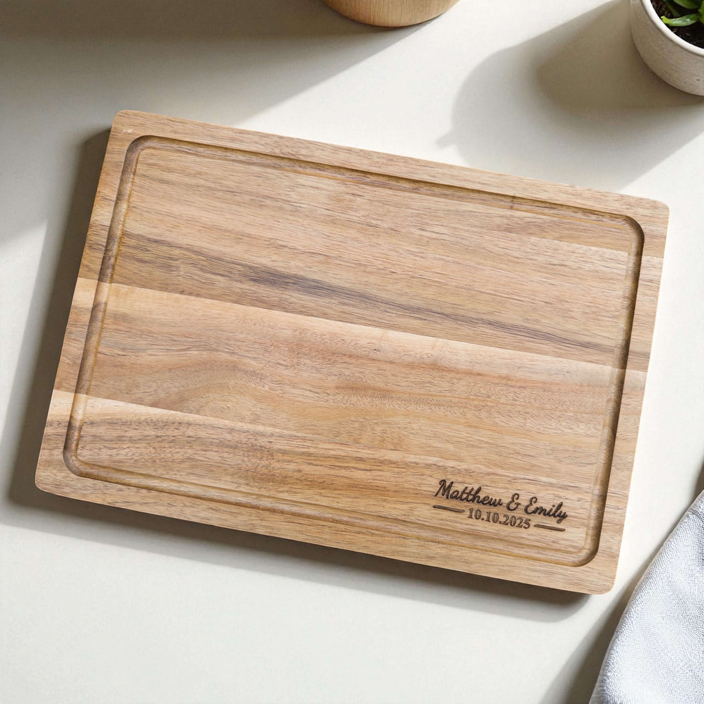 Elegant acacia wood cutting board personalised with names and wedding date, unique engagement or bridal shower gift idea.