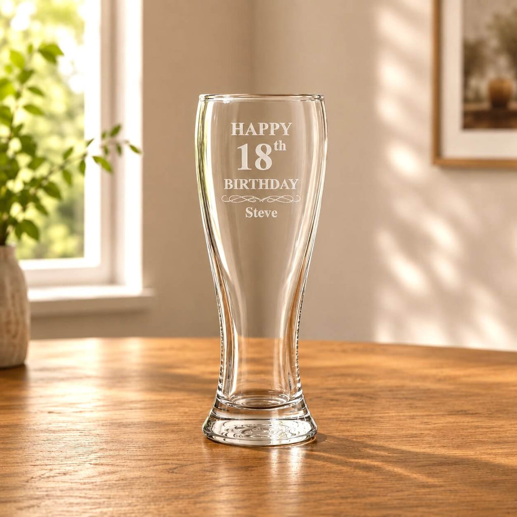 Engraved beer glass with Happy 18th Birthday design shown in warm natural light