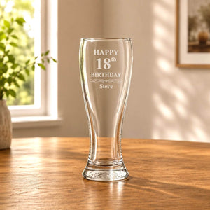 Engraved beer glass with Happy 18th Birthday design shown in warm natural light