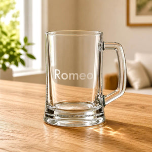 Engraved beer tankard with Romeo name, thick glass base and warm home background