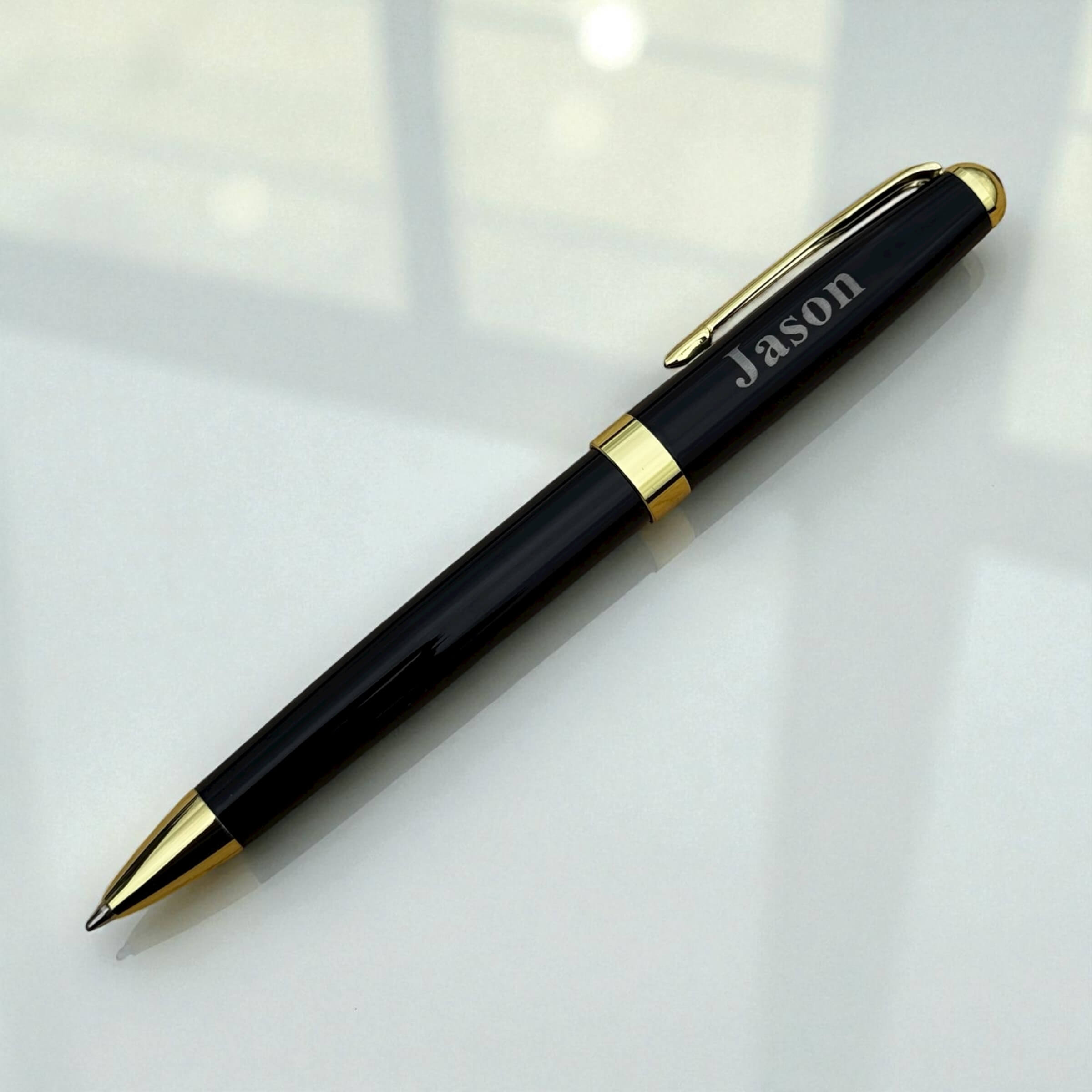 Engraved black and gold pen with name styled under natural light