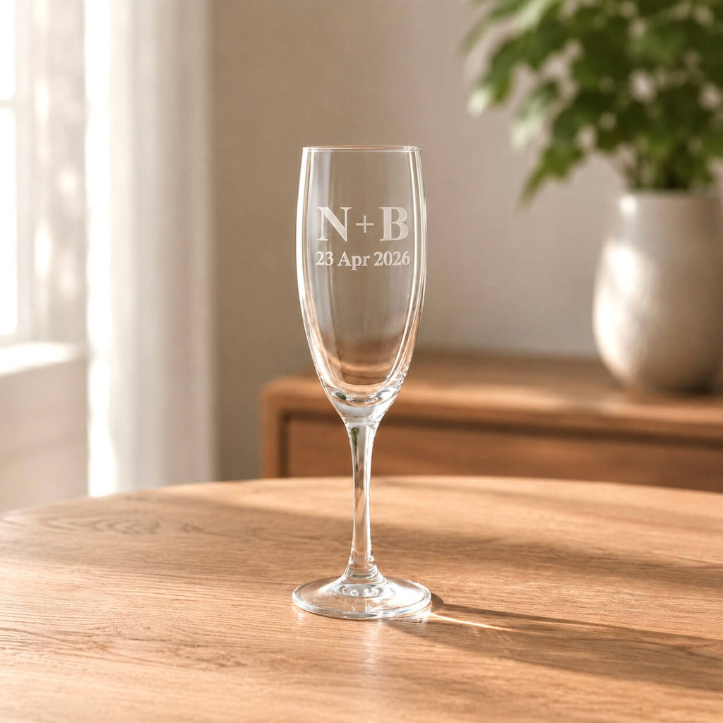 Engraved champagne flute showing N+B and 23 Apr 2026 on clear glass