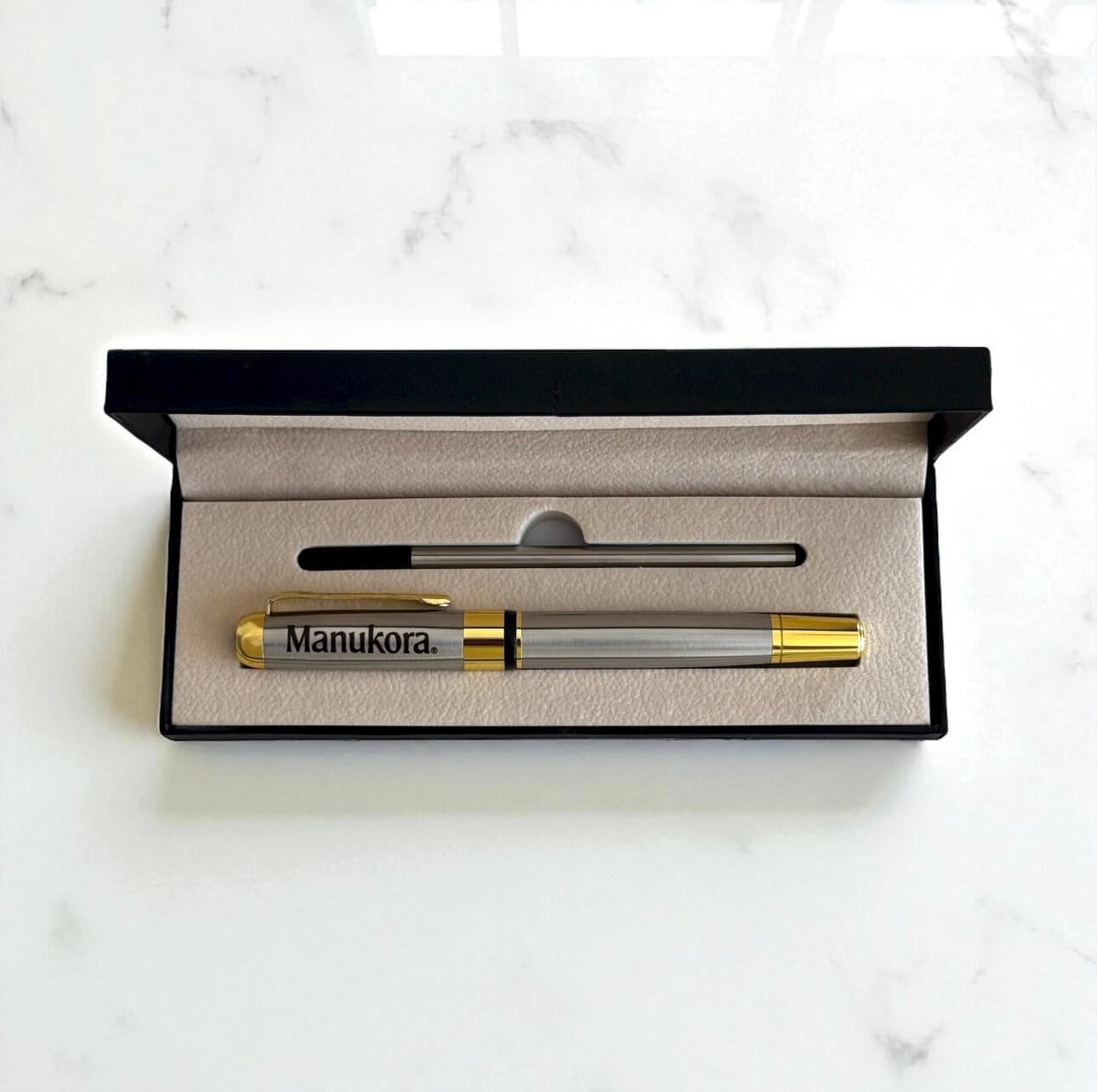 Engraved metal pen presented in black gift box with refill insert, ready for gifting.