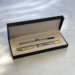 Engraved silver and gold metal pen reading 'Duana' displayed inside a black gift box with refill included