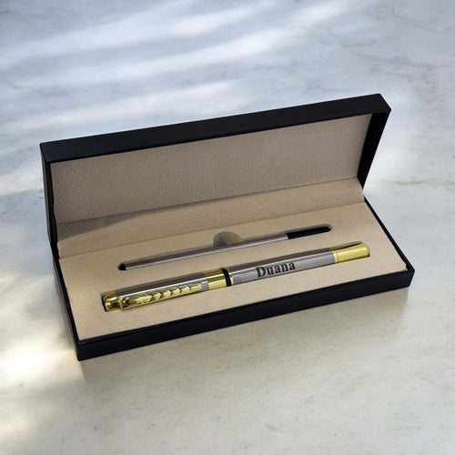 Engraved silver and gold metal pen reading 'Duana' displayed inside a black gift box with refill included