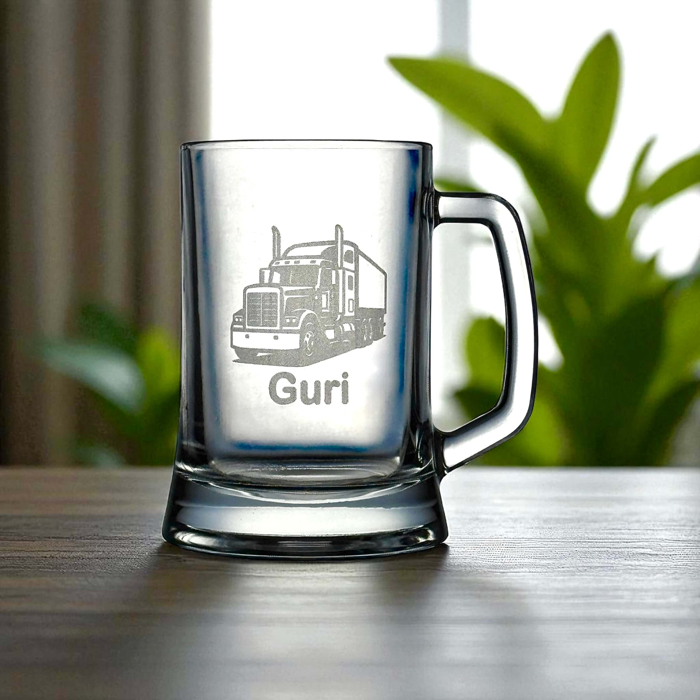 Engraved trucker beer glass with handle and name detail, styled with natural greenery background.