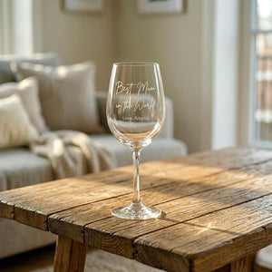Engraved wine glass gift for Mum on wooden coffee table in sunlit lounge, personalised with name
