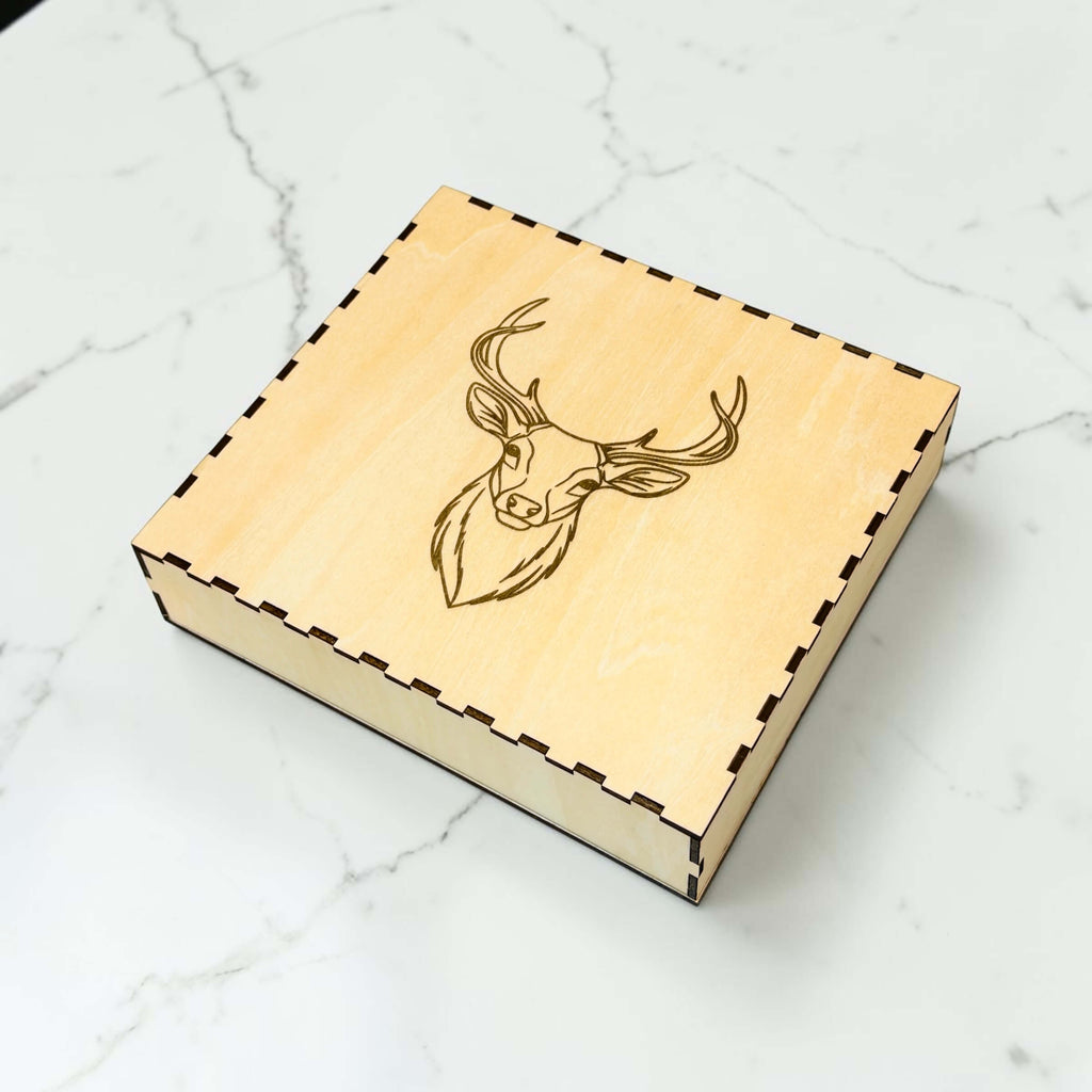 Engraved wooden gift box for hip flask set with stag design on marble background
