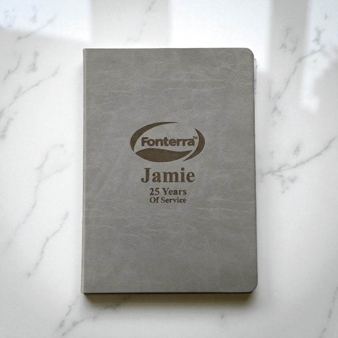 Grey personalised A4 hardcover journal with engraved company logo and employee name, ideal for corporate gifts and service awards in New Zealand.