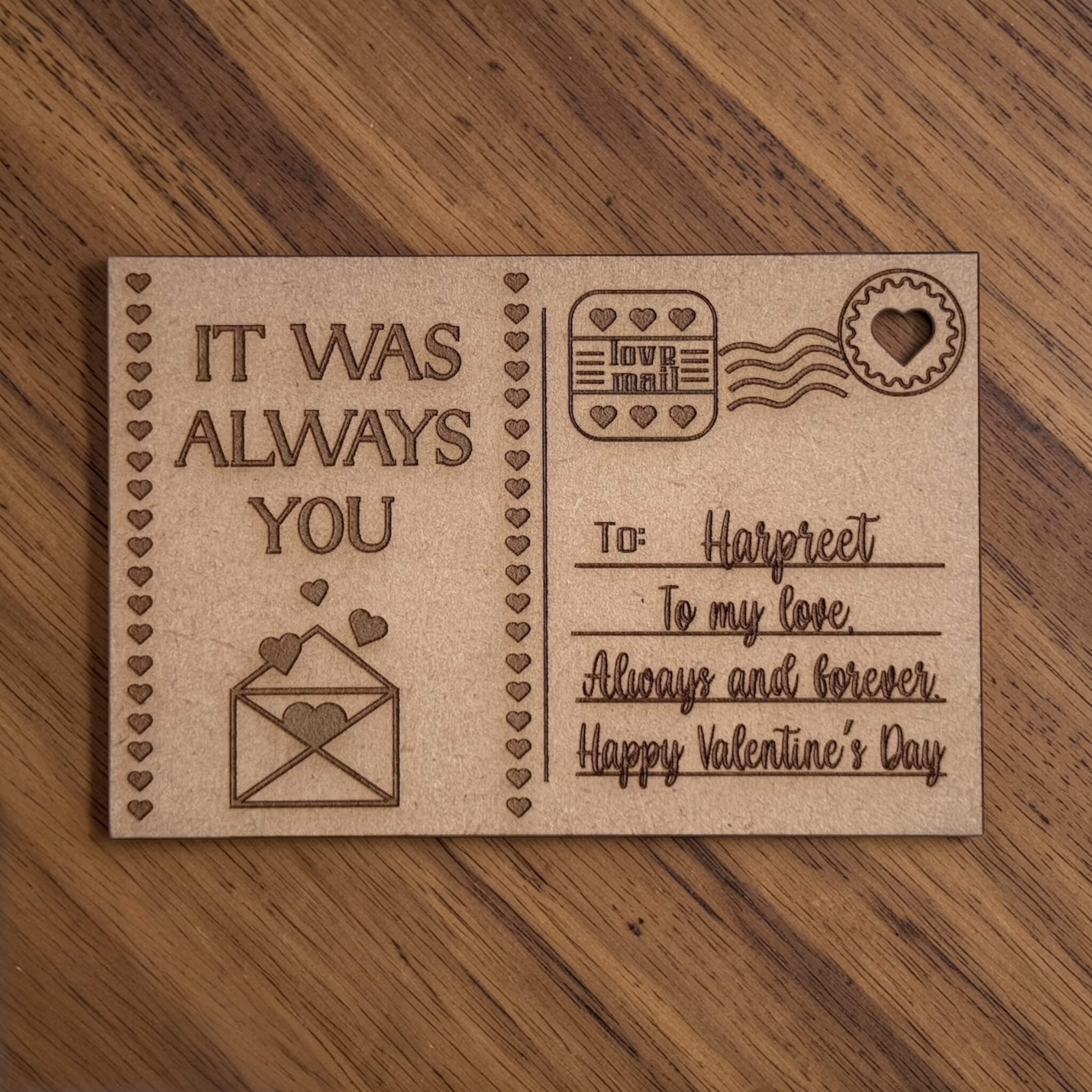 Laser engraved wooden Valentine's Day postcard with personalised name and message, custom MDF love postcard gift flat lay on wood surface