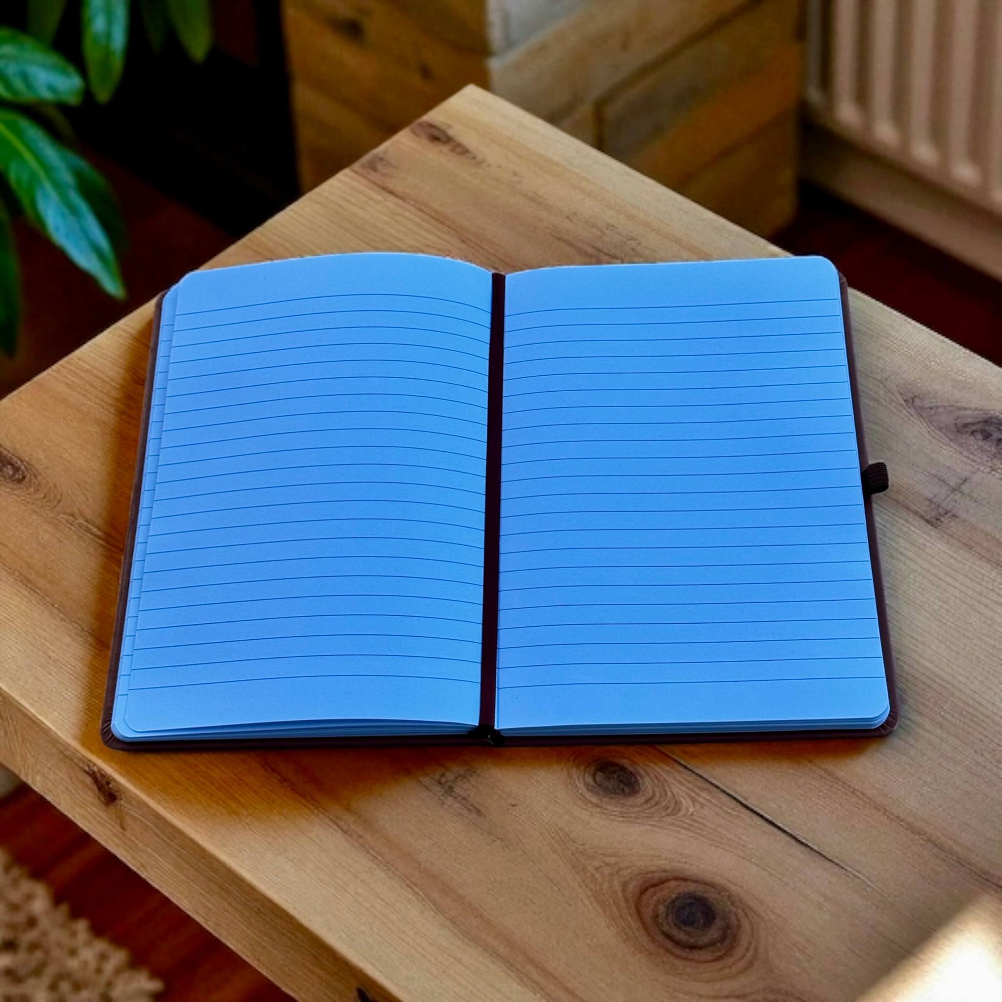 Open notebook on a wooden surface with a blurred indoor background