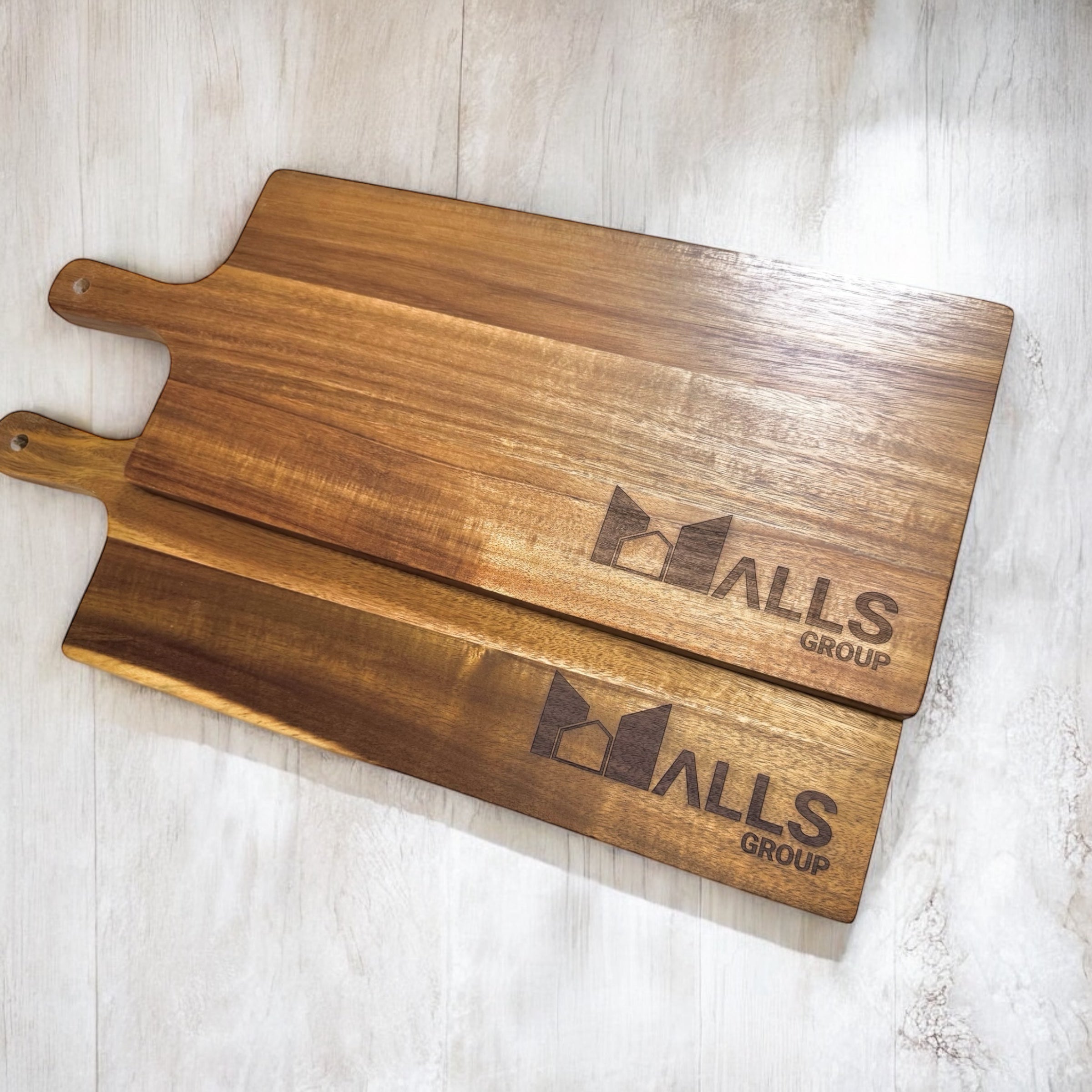 Pair of business-branded serving boards showcasing smooth grain and custom etching