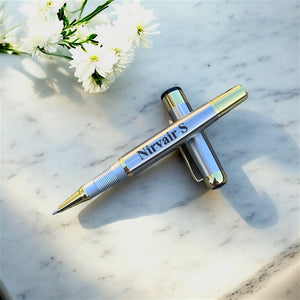 Personalised Silver pen with gold accents on a marble surface with white flowers.