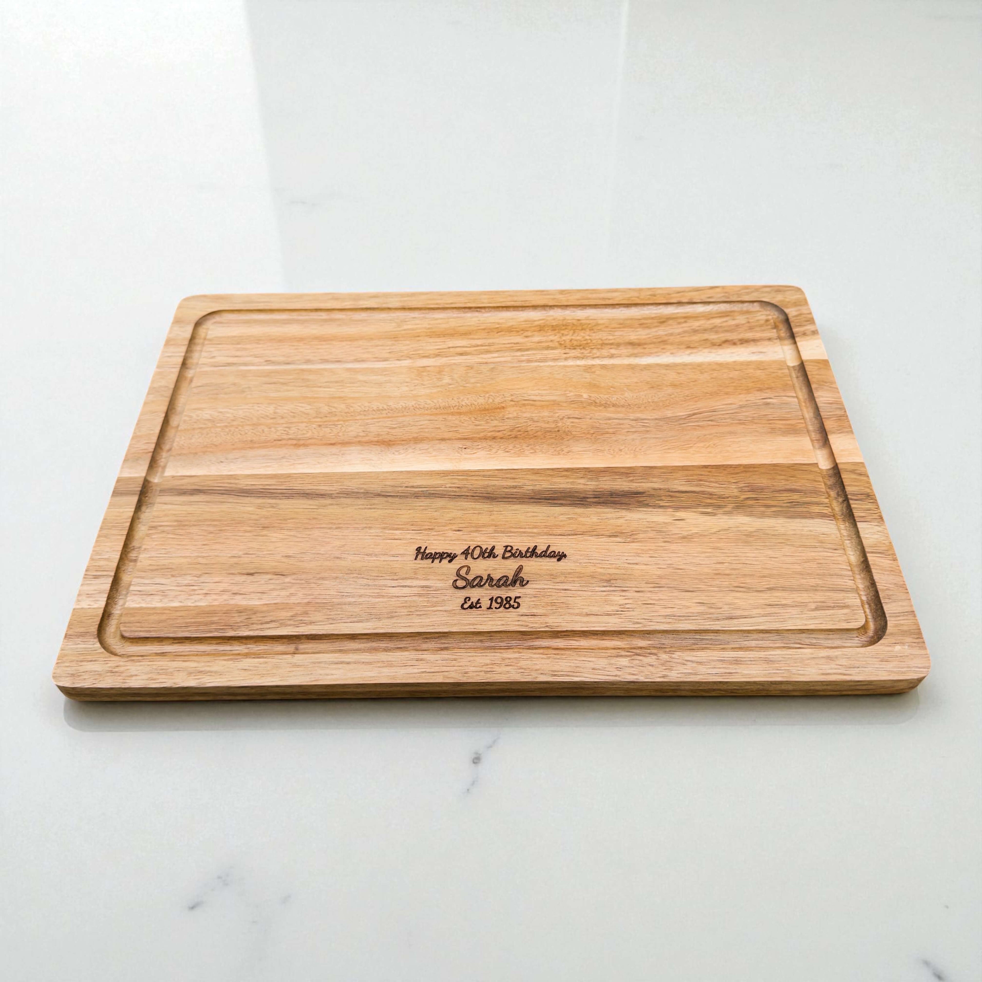 Personalised acacia chopping board engraved with Happy 40th Birthday Sarah Est 1985, custom wooden gift for milestone birthdays or special occasions.