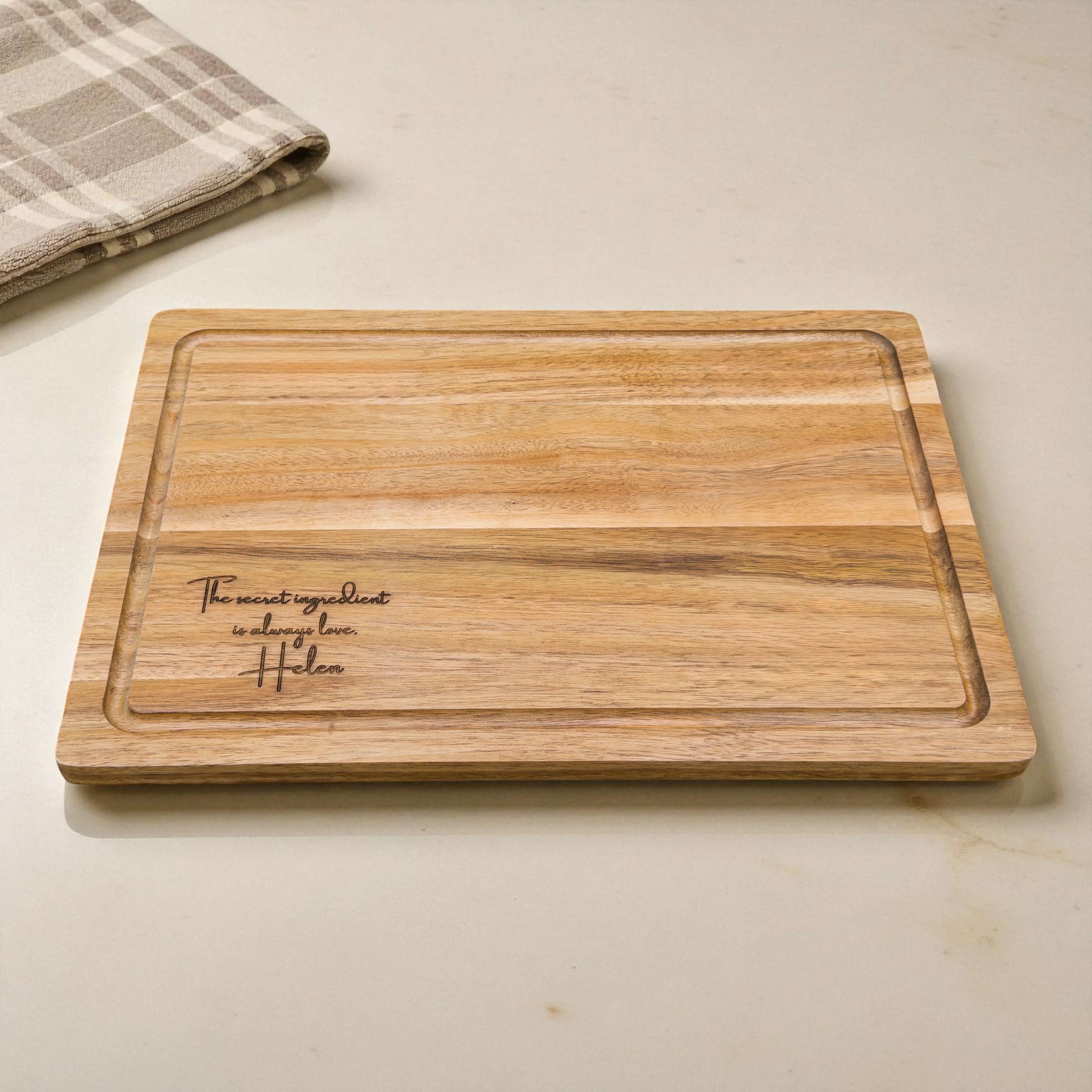 Personalised acacia wood chopping board engraved with meaningful quote and name, elegant wooden gift for any home chef or loved one.