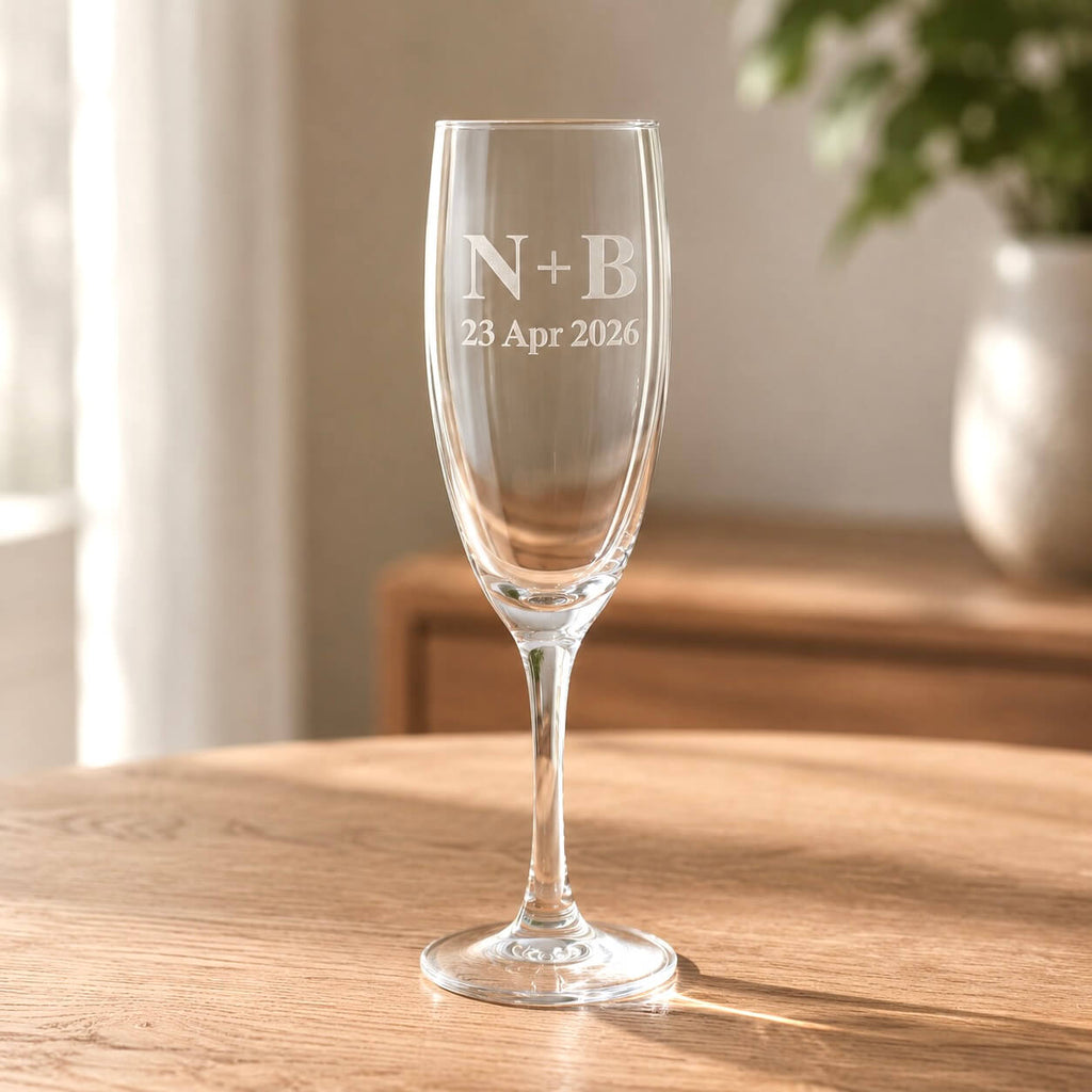 Personalised anniversary champagne flute with initials and date on a wooden table