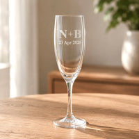 Personalised anniversary champagne flute with initials and date on a wooden table