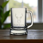 Personalised beer glass featuring stag head engraving and custom name detail, set against a bright window background.