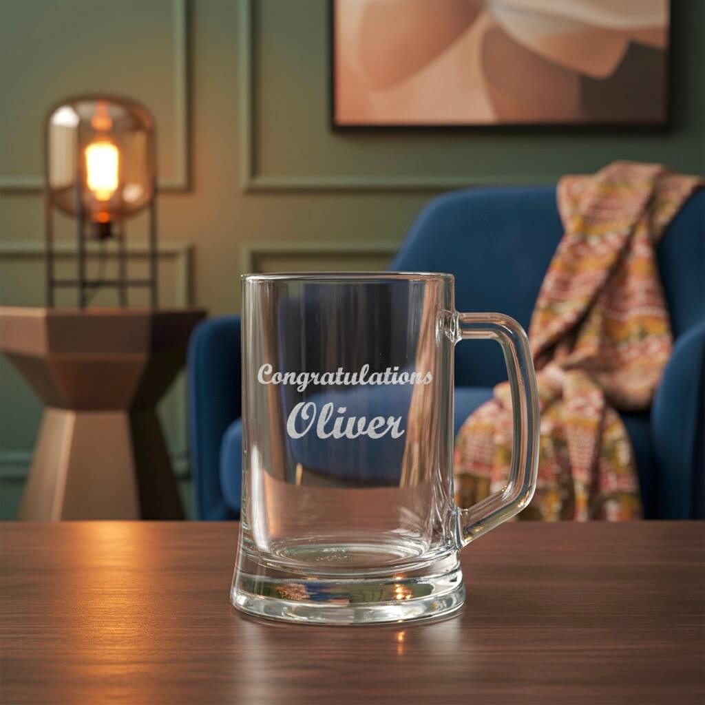 Personalised beer handle gift engraved with “Congratulations Oliver” placed in stylish home setting with lamp and blanket in background