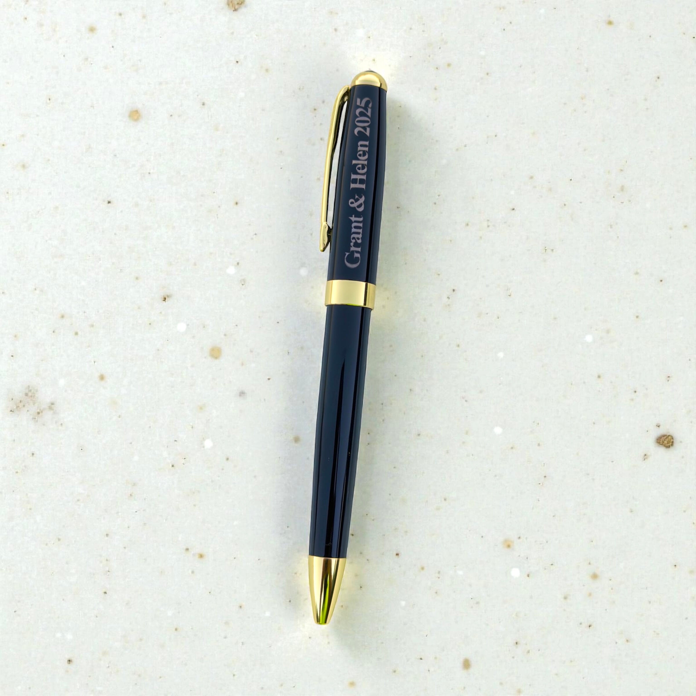 Personalised black ballpoint pen engraved with Grant and Helen 2025 and finished with gold trim