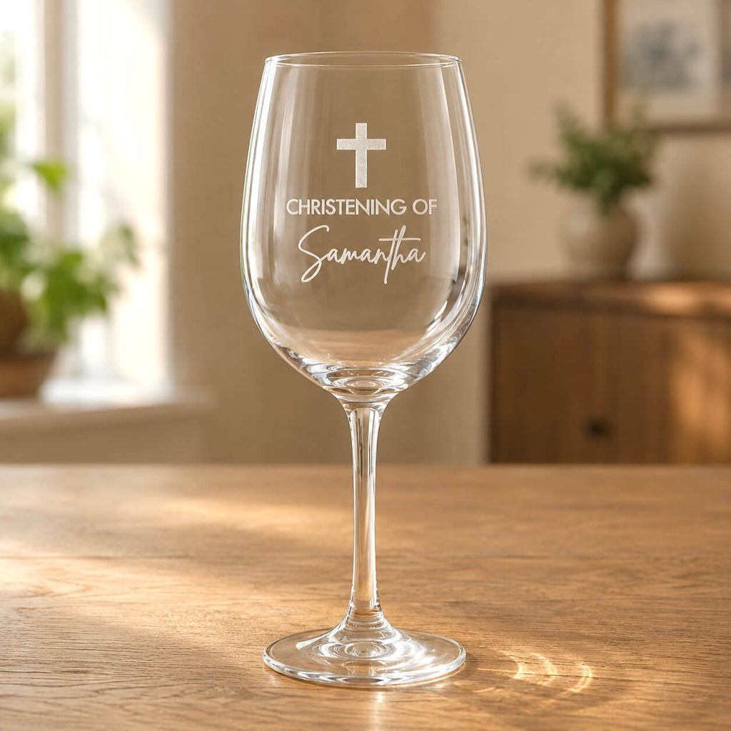 Personalised christening wine glass with cross and Samantha name engraving on a wooden table