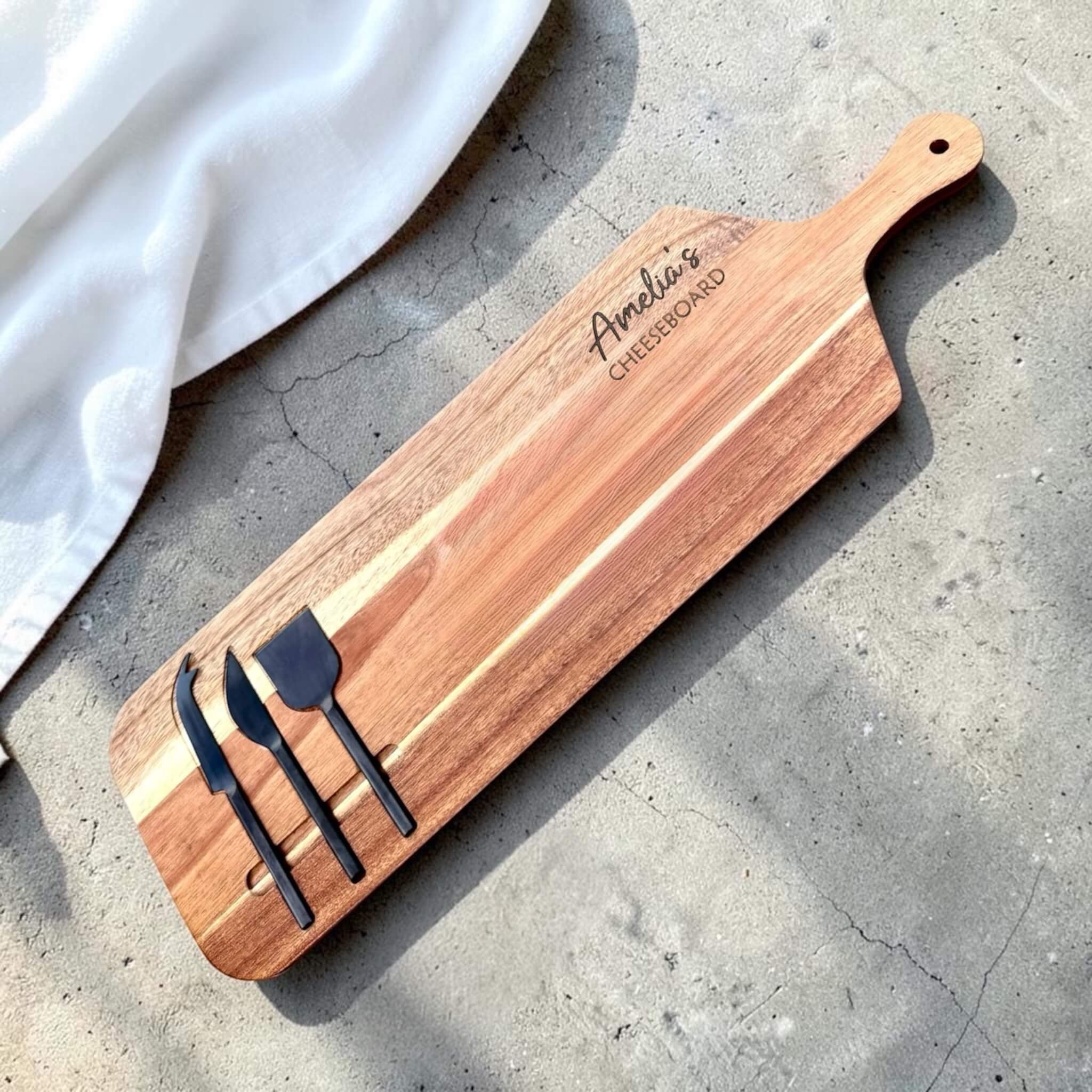 Personalised engraved acacia wood cheeseboard with custom name engraving and three black cheese knives in built-in slots, unique gift idea NZ