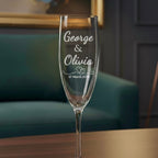 Personalised engraved champagne flute with names George and Olivia and date 27 March 2024 on wooden table