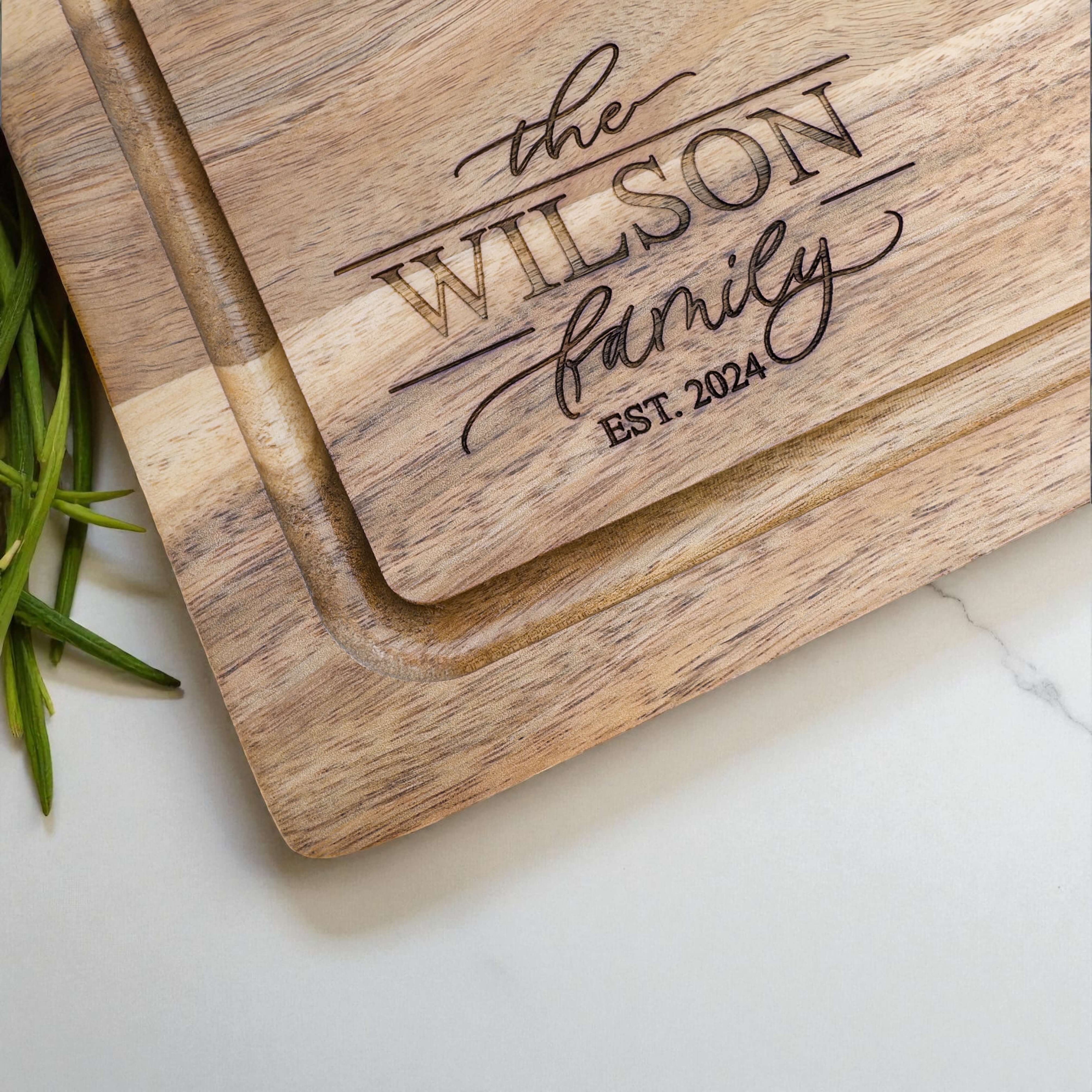 Personalised family name chopping board engraved with The Wilson Family Est. 2024, custom acacia wood gift for new home or housewarming.