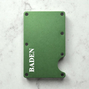 Personalised green metal card holder with engraved name on a marble surface