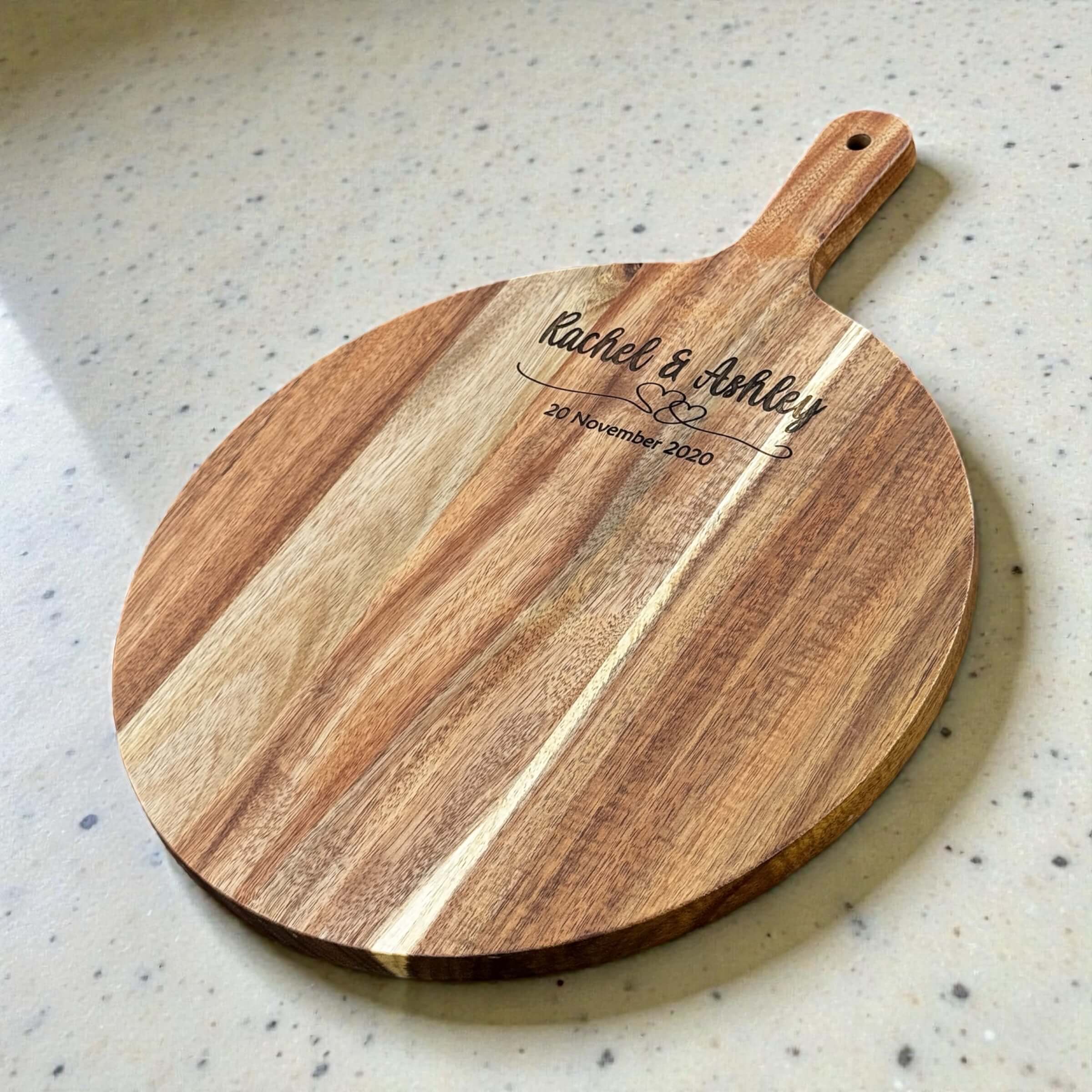 Personalised wedding gift serve board with laser engraved names and date, round acacia wood paddle board with natural grain