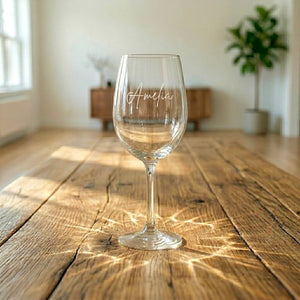 Personalised wine glass with Amelia name engraving on a rustic wooden table