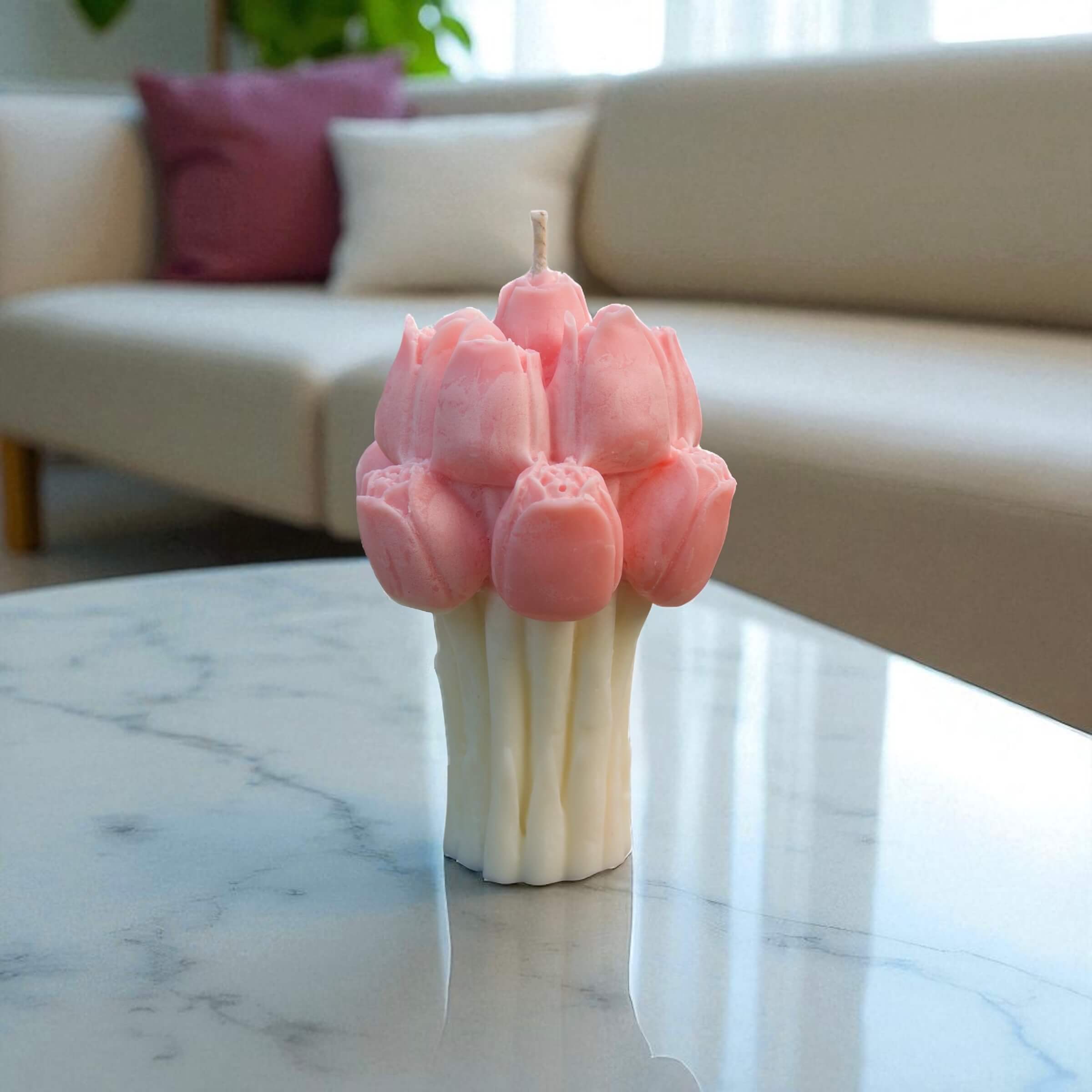 Realistic pink tulip bloom candle for gifting or decor, shown on a marble tabletop with soft lounge background.