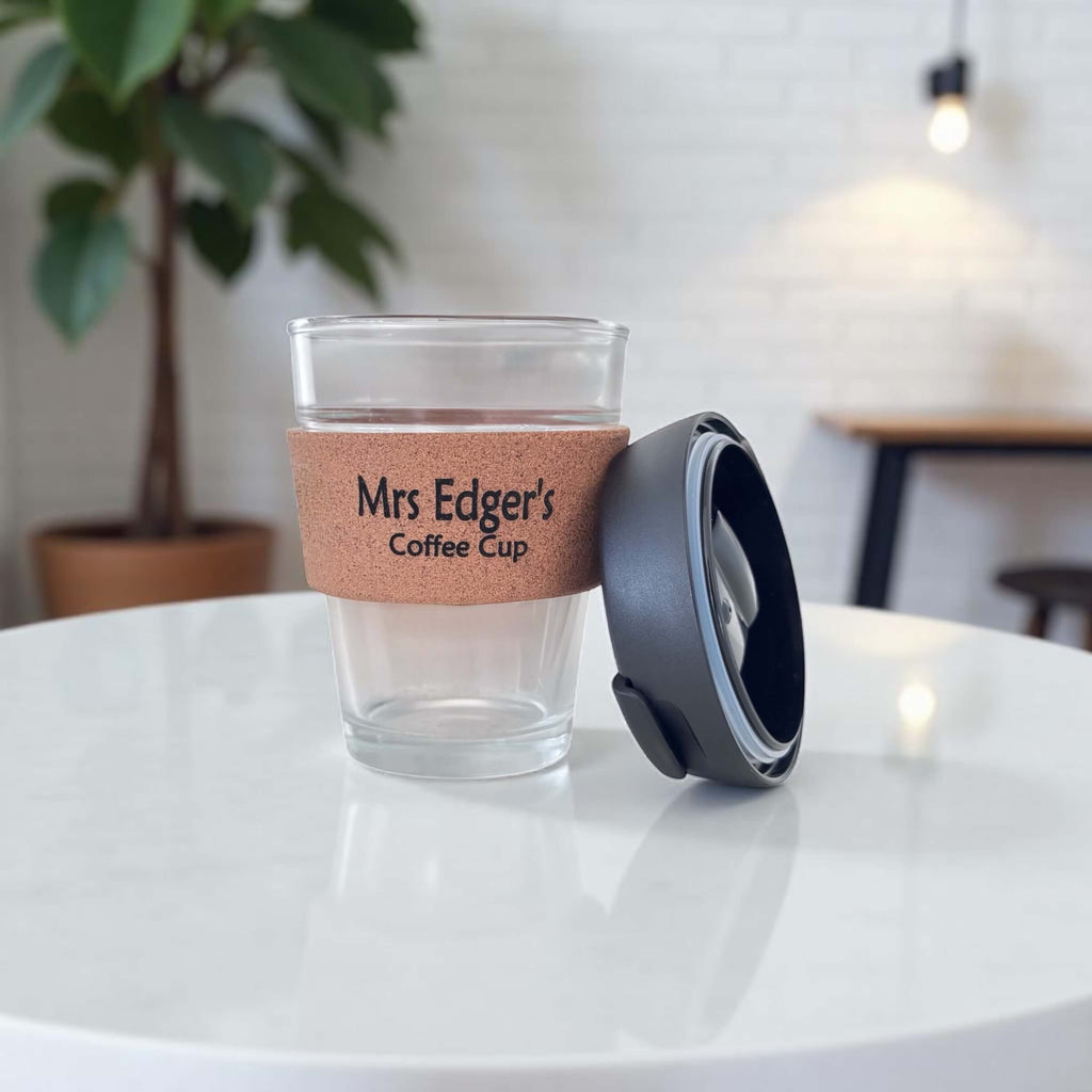 Reusable eco-friendly coffee cup with cork band engraved “Mrs Edger’s Coffee Cup” and lid beside it
