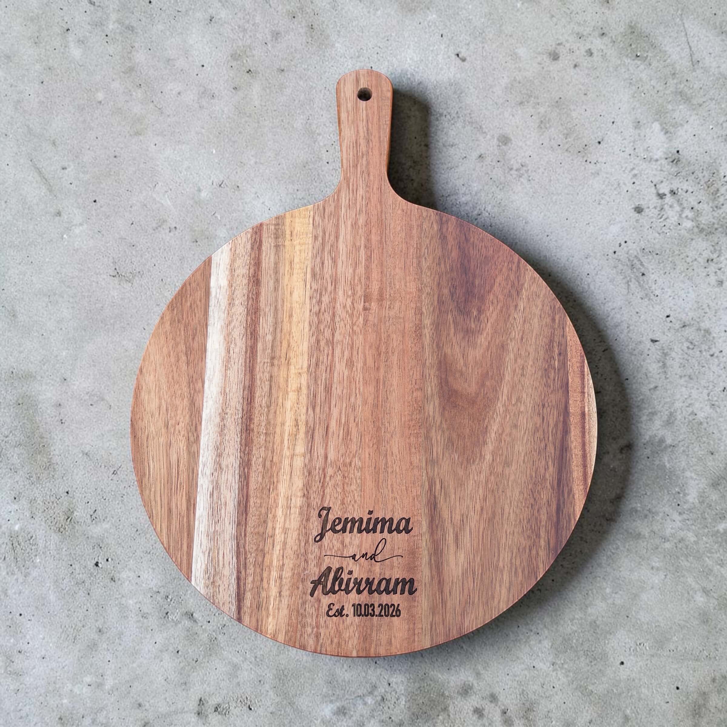 Round acacia serving board engraved with Jemima and Abirram wedding date