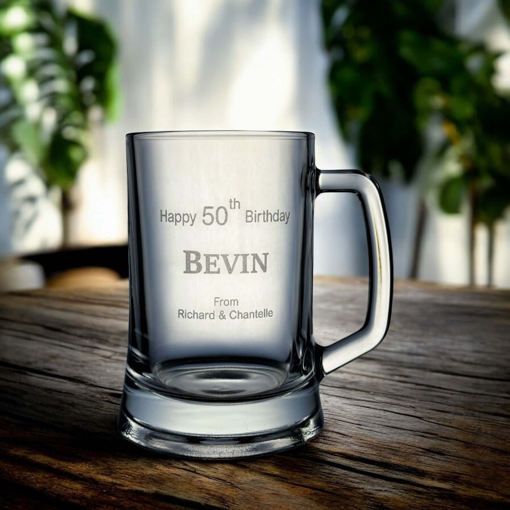 Side angle of engraved beer mug showing full name and birth year against a wooden surface.