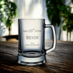 Side angle of engraved beer mug showing full name and birth year against a wooden surface.