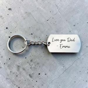 Silver personalised keyring for Dad engraved with Love you Dad - Emma on grey concrete