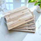 Stack of personalised chopping boards engraved with couples’ names.