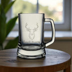 Stag engraved beer glass with sturdy handle, personalised with name, styled on a round wooden tabletop.