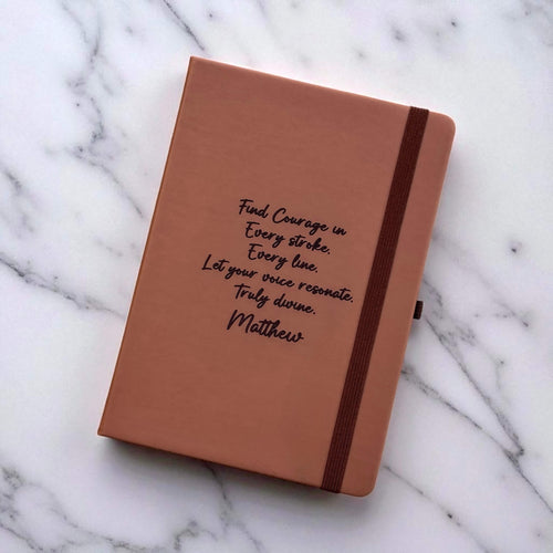 Tan notebook with custom text on a marble surface