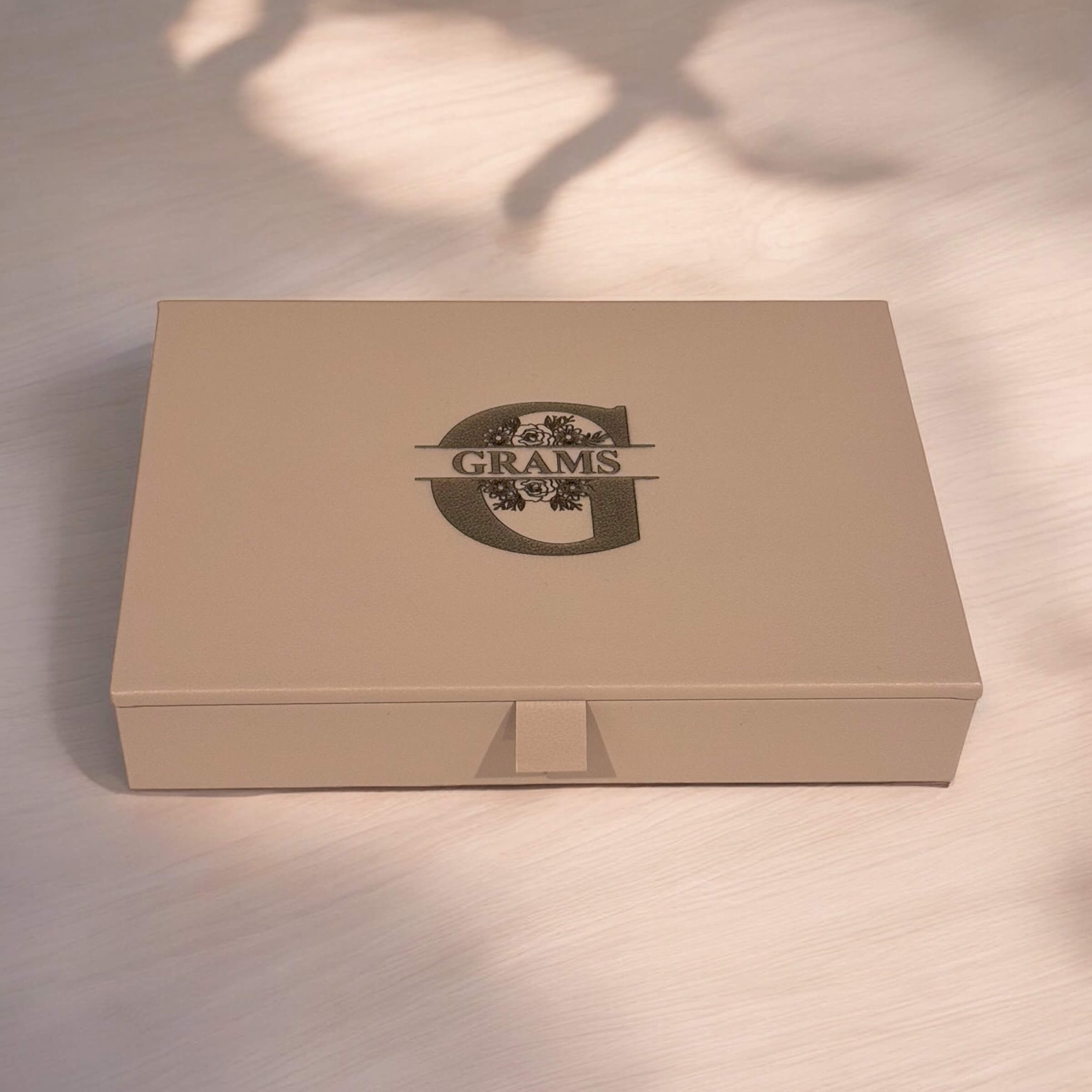 Taupe PU leather jewellery holder engraved with custom initials, styled on a dresser.