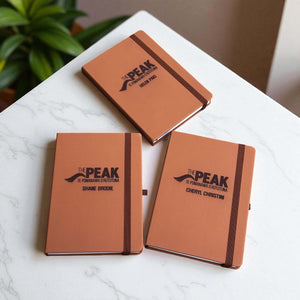 Three engraved leather journals displayed together, highlighting personalisation options.