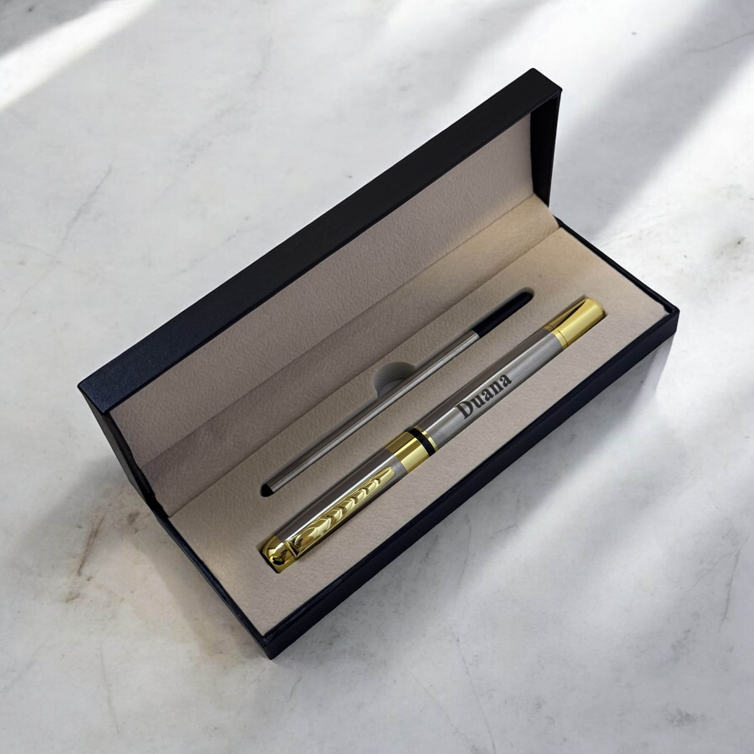 Top-down angled view of engraved pen in presentation case, highlighting elegant detailing and soft interior lining