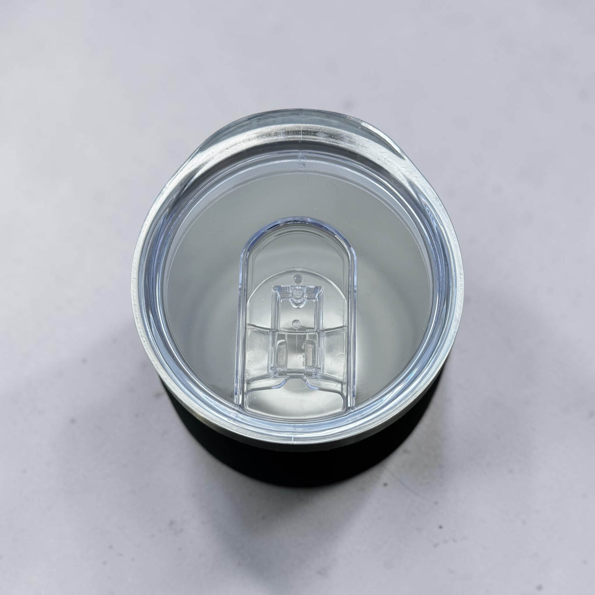 Top view of 300ml corporate coffee with a clear lid on a light grey background