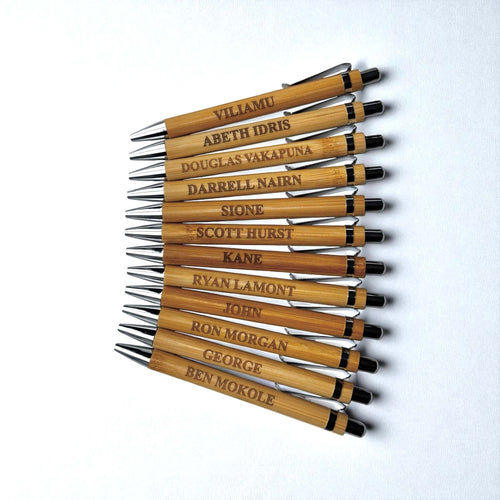Top view of engraved bamboo promotional pens, each personalised with a different name.